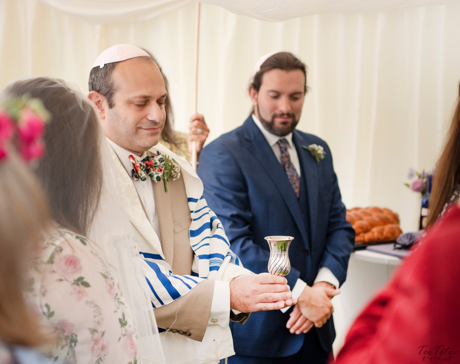 Holding silver cup at Jewish wedding